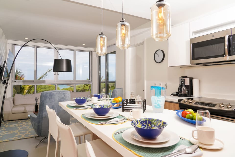 Your stylish dining space opens to breathtaking ocean views through floor-to-ceiling windows, where meals become memorable moments with nature's backdrop just beyond the glass.