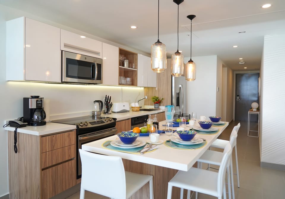 Picture yourself cooking in this bright, modern kitchen with sleek appliances, warm wood accents, and a welcoming island where you can gather for breakfast or a casual meal.