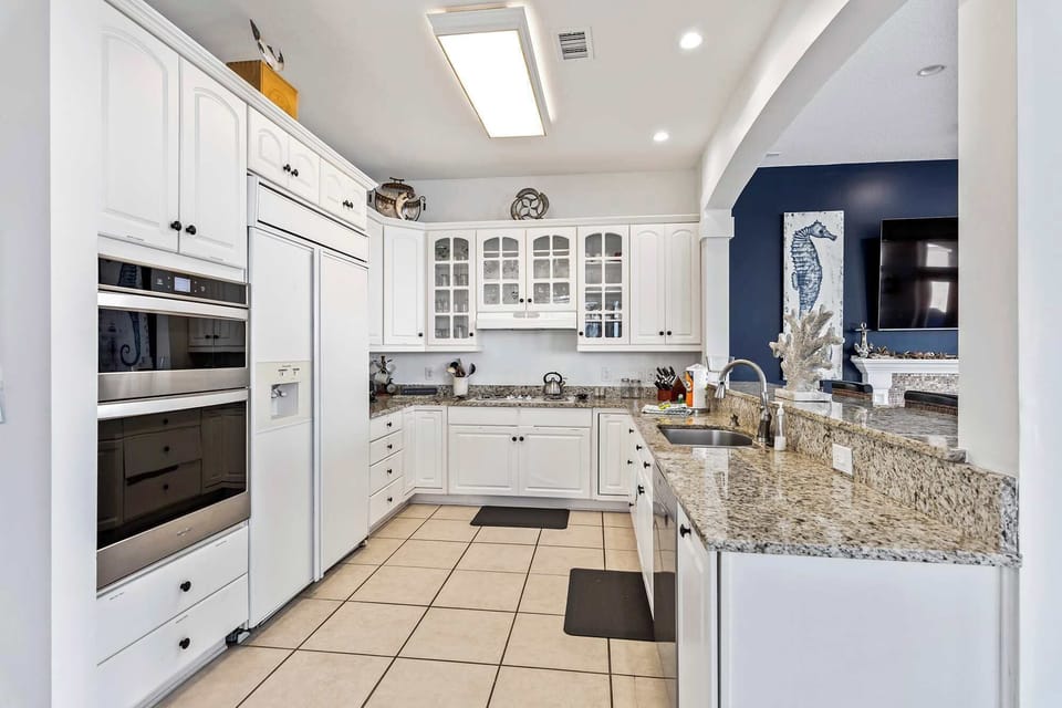 Sleek kitchen w/ granite counters, ample cabinetry, & plenty of prep space.