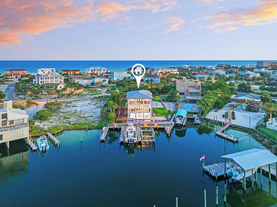 Aerial marina view capturing calm water, boats, & the surrounding neighborhood.