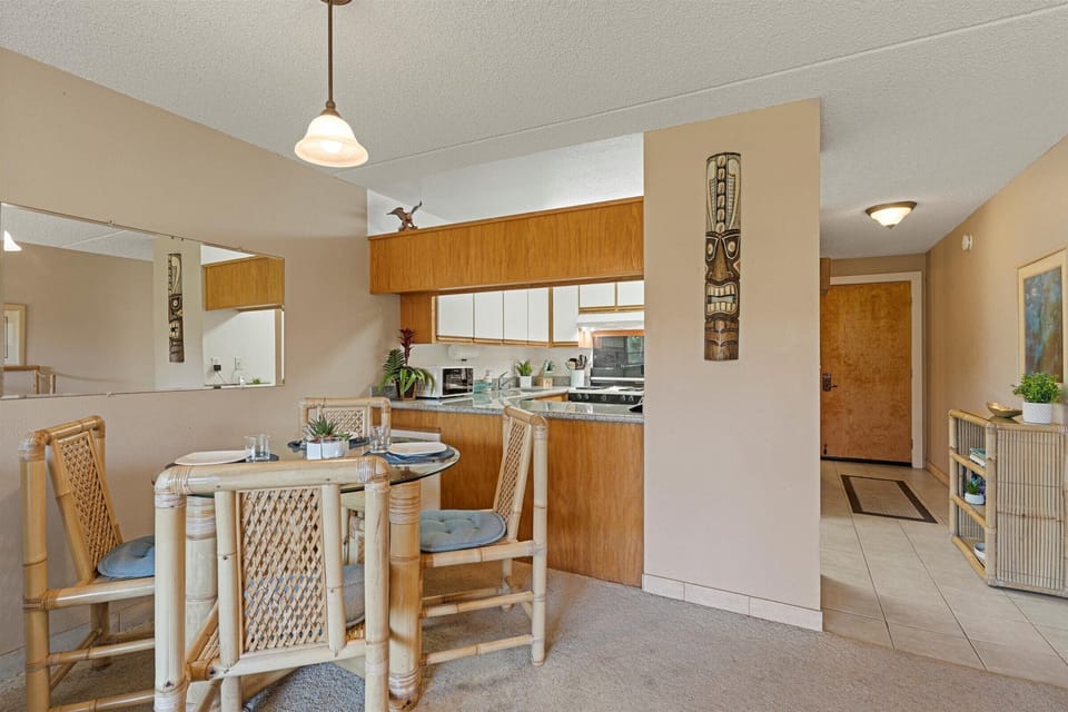 Your open-concept kitchen and dining space welcomes you with warm wood tones and tropical charm, perfect for enjoying meals together at the cozy table for four.