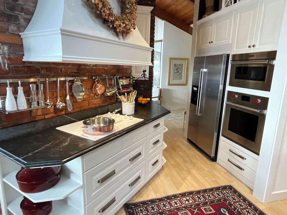 Soapstone countertops & quality cookware.  Wolf convection oven and microwave.