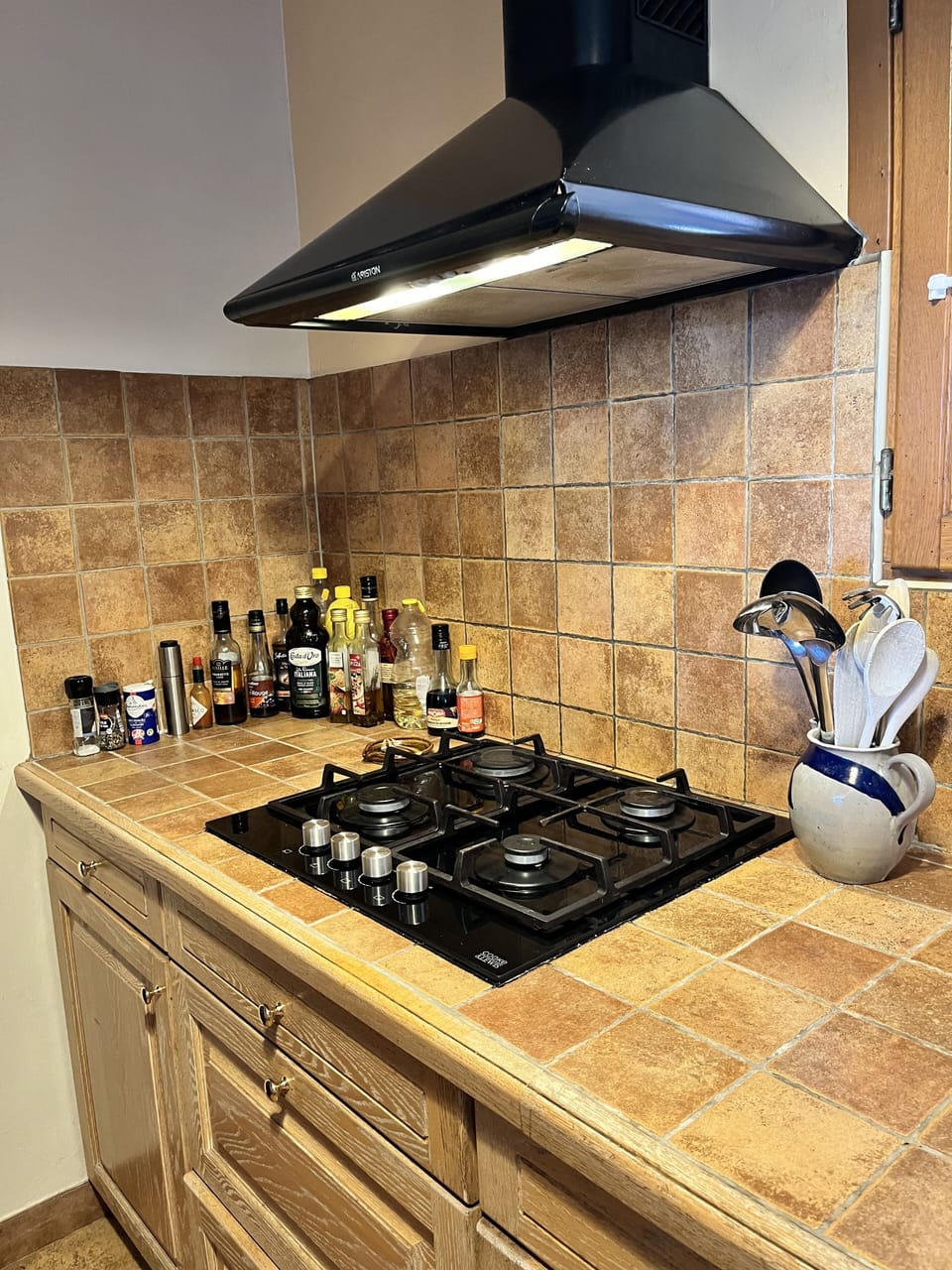 Gas hob with extractor, oils and vinegars, spices galore with pots and pans