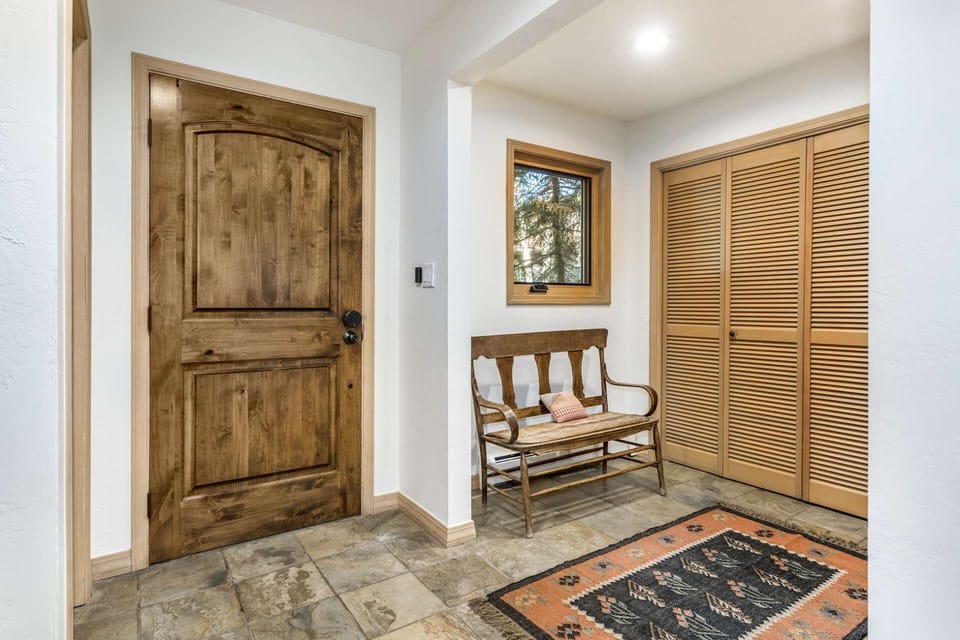 Entry way features a bench and closet.