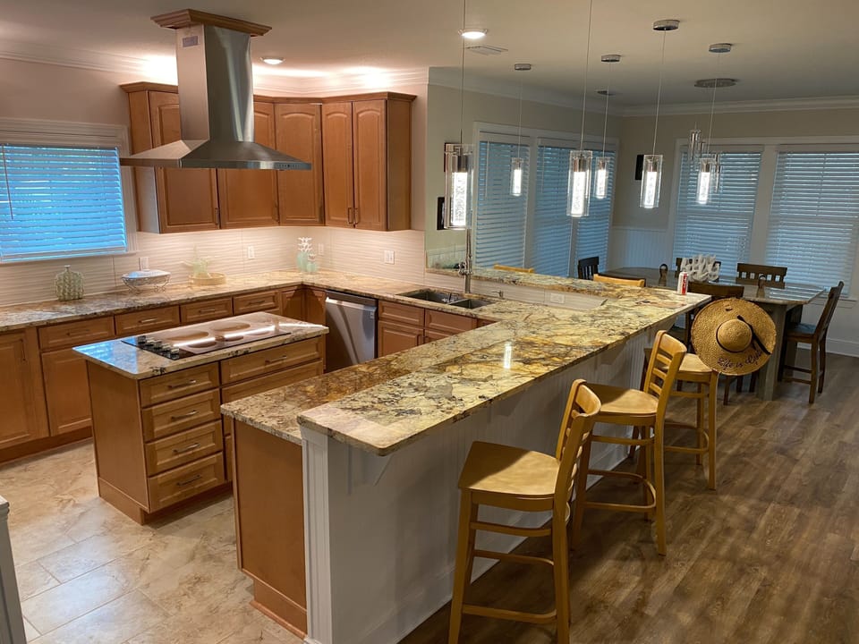 Kitchen has an island top stove, oven/microwave combo, a large walk in pantry