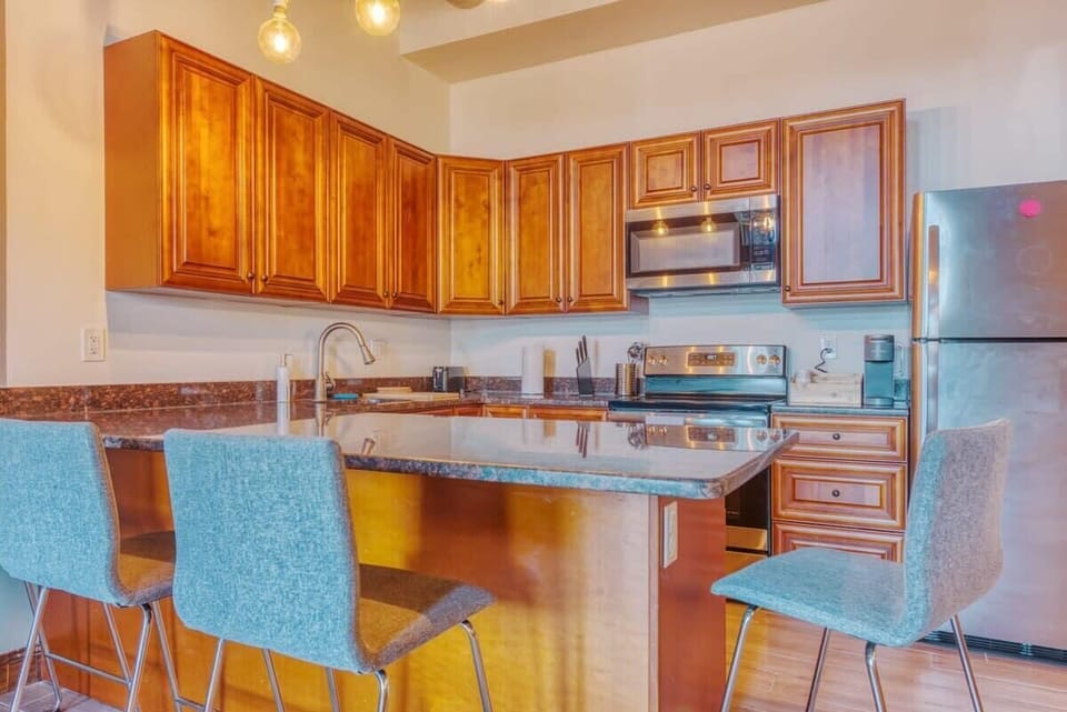 Enjoy home-cooked or the neighborhood's best takeout in this lovely kitchen with stainless steel appliances, a microwave, and a full-sized refrigerator.