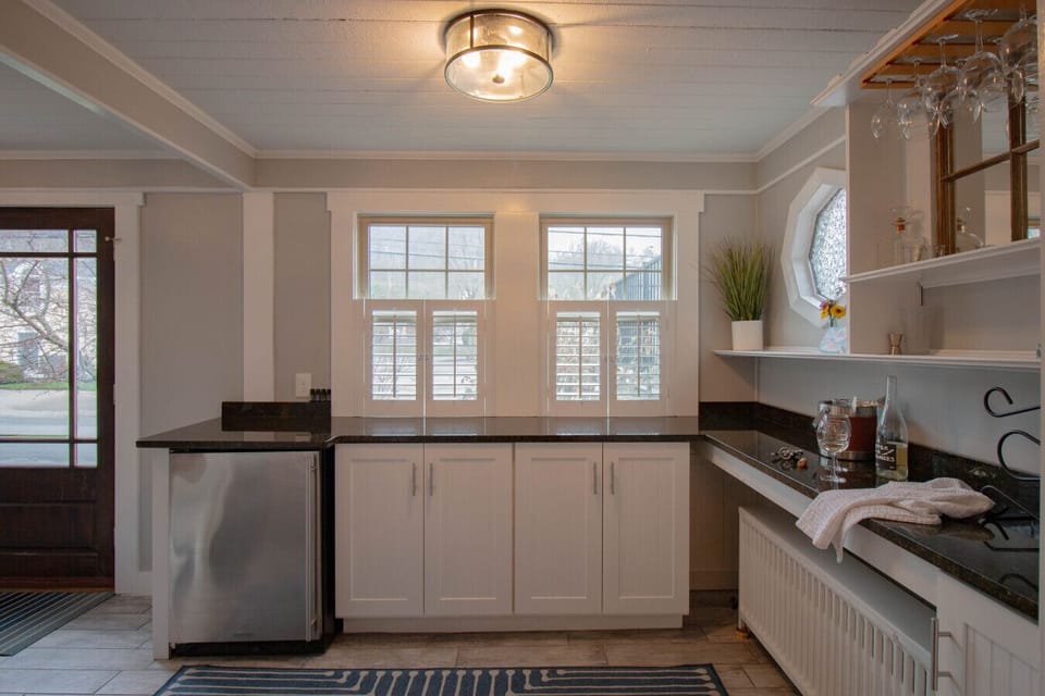 Spacious bar area featuring a granite counter, beverage fridge, and all the essentials for mixing drinks.