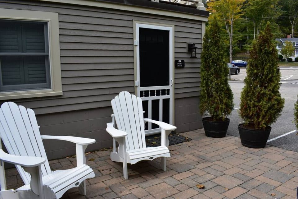 Private patio space featuring two Adirondack chairs and a small bistro table.