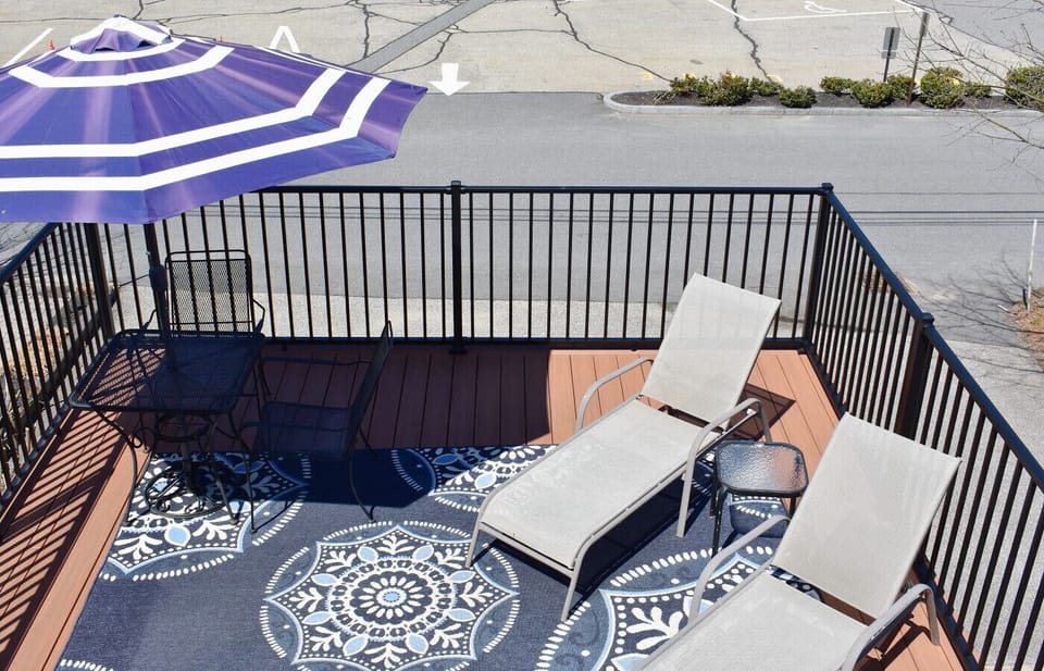 Spacious private deck with full sun, tanning loungers, and a small outdoor table.