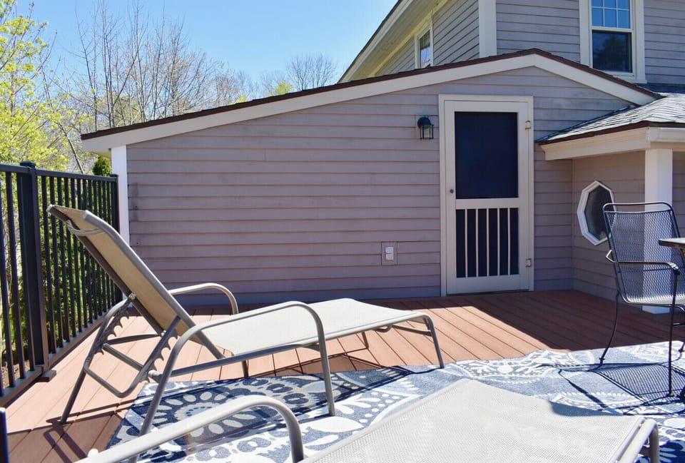 Spacious private deck with full sun exposure, tanning loungers, and a small outdoor table.