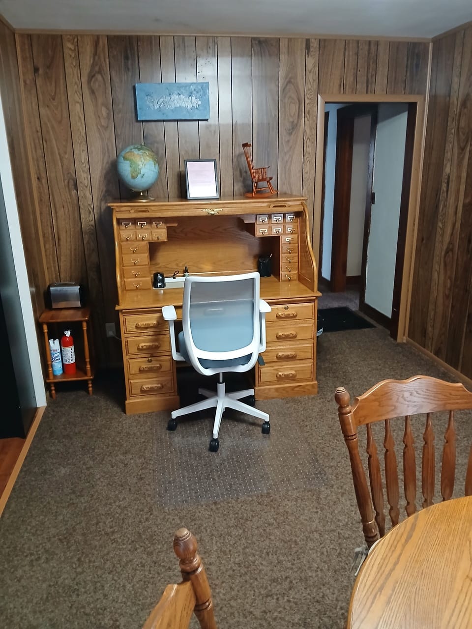 Office desk and chair located in dining room.