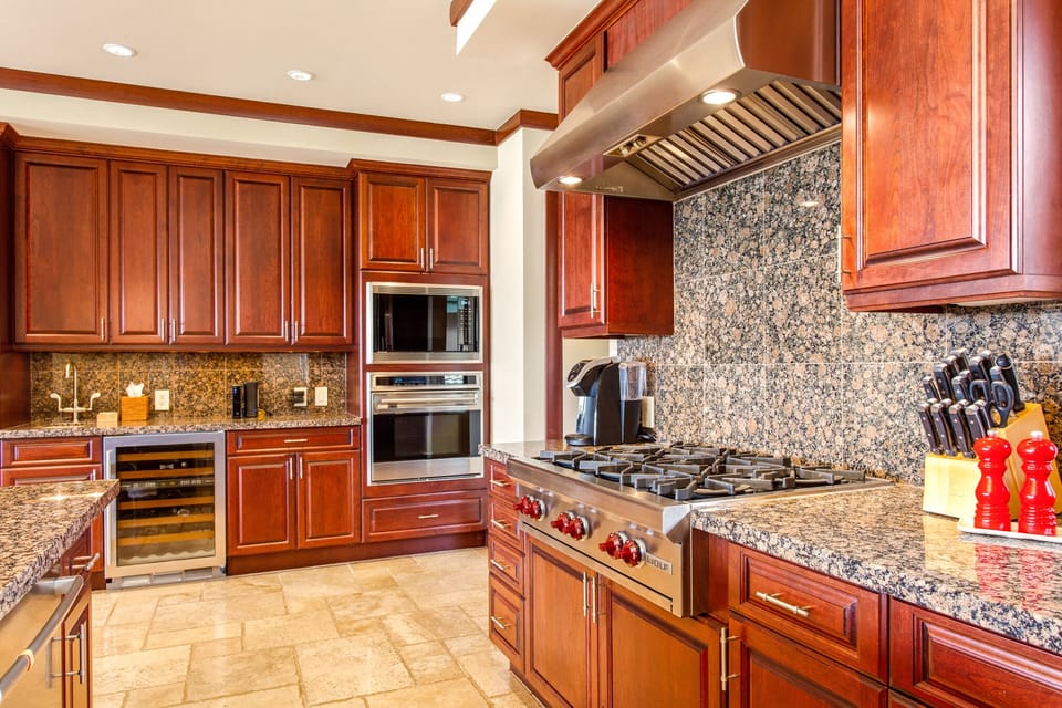 A chef’s dream kitchen with rich wood cabinetry, granite counters, and high-end Wolf and Sub-Zero appliances.