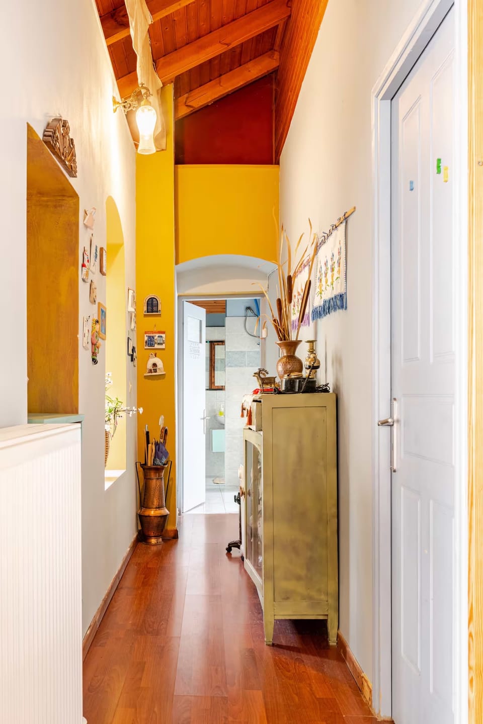Bright wooden hallway connecting rooms, accented with warm lighting and cozy tones.