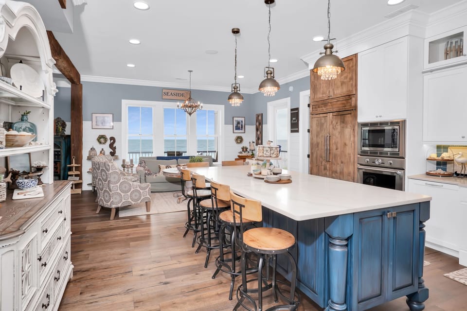 Gather around this stunning kitchen island where coastal charm meets modern comfort—your culinary adventures begin here with ocean views as your backdrop.