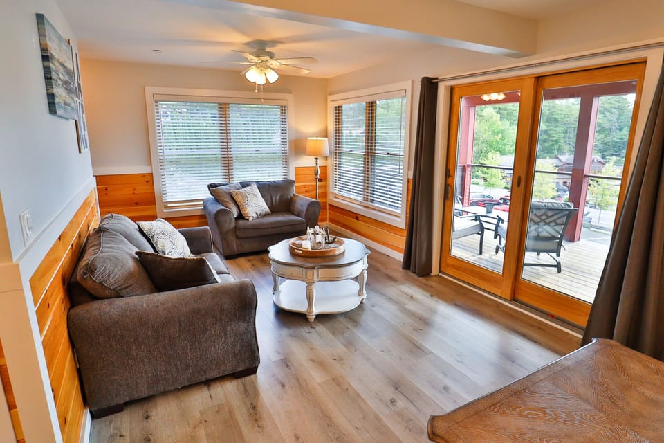 Spacious living room with a pull-out sofa bed and a sliding glass door.