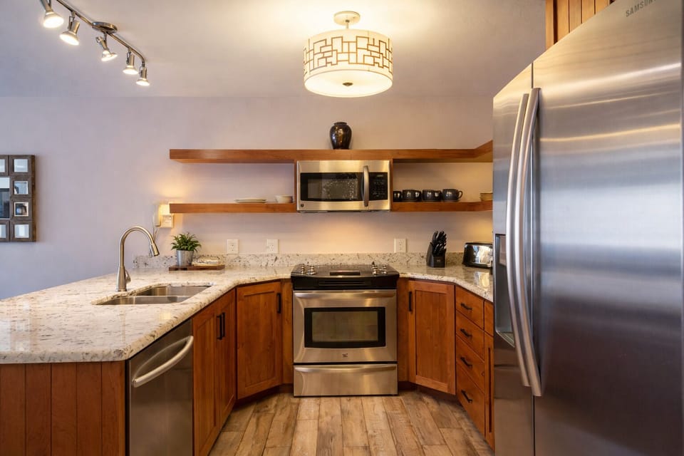 Prepare favorite meals and après-ski snacks in the updated kitchen featuring granite countertops, stainless appliances, and everything needed for a comfortable stay.