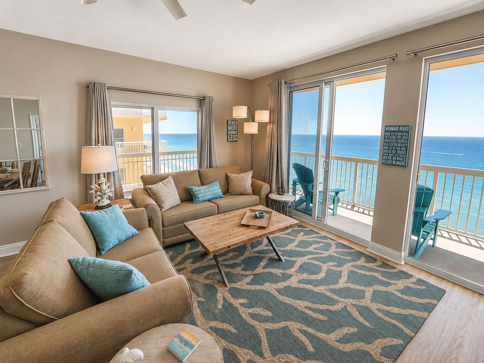 Sink into plush seating while endless ocean views fill your horizon through floor-to-ceiling windows in this bright, coastal-inspired living room.