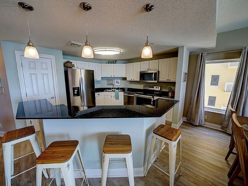 Your fully equipped kitchen features granite countertops, modern appliances, and a breakfast bar perfect for morning coffee or casual meals.