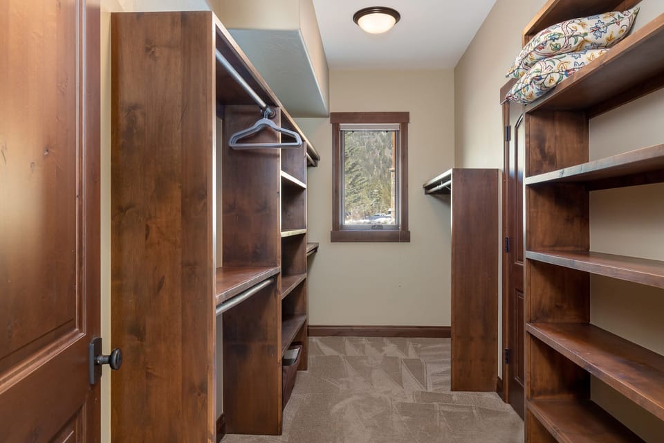 Your spacious walk-in closet offers plenty of room to organize your belongings with custom wood shelving and hanging space.