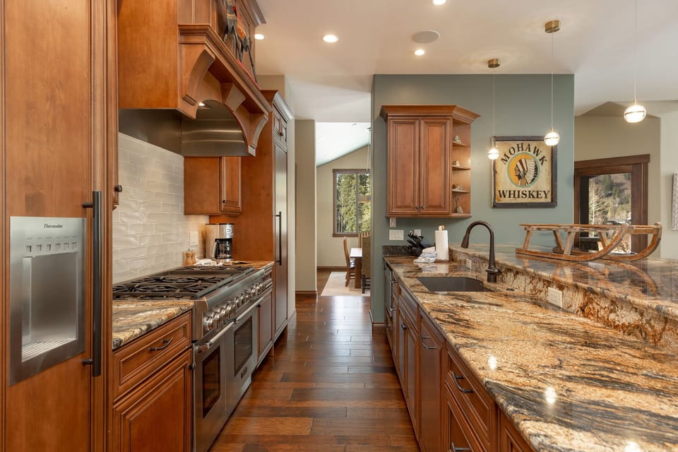 Your gourmet kitchen features rich wood cabinetry, granite countertops, and premium appliances perfect for creating memorable meals together.