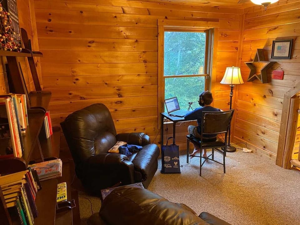 Upstairs loft area with two massage chairs, desk with a view and books