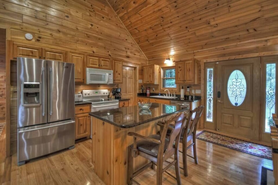 Fully stocked kitchen with 2 seats at the breakfast bar and laundry room by the sink