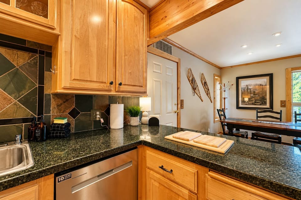 Your fully-equipped kitchen awaits with warm wood cabinetry, granite countertops, and everything you need to prepare delicious meals during your stay.