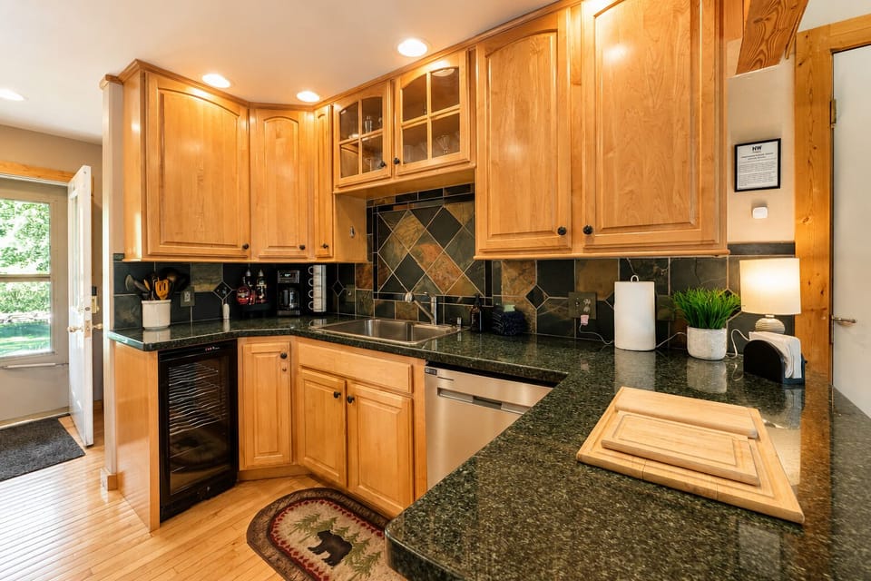 Your fully equipped kitchen features warm wood cabinetry, granite counters, and stainless appliances—perfect for cooking memorable meals during your stay.