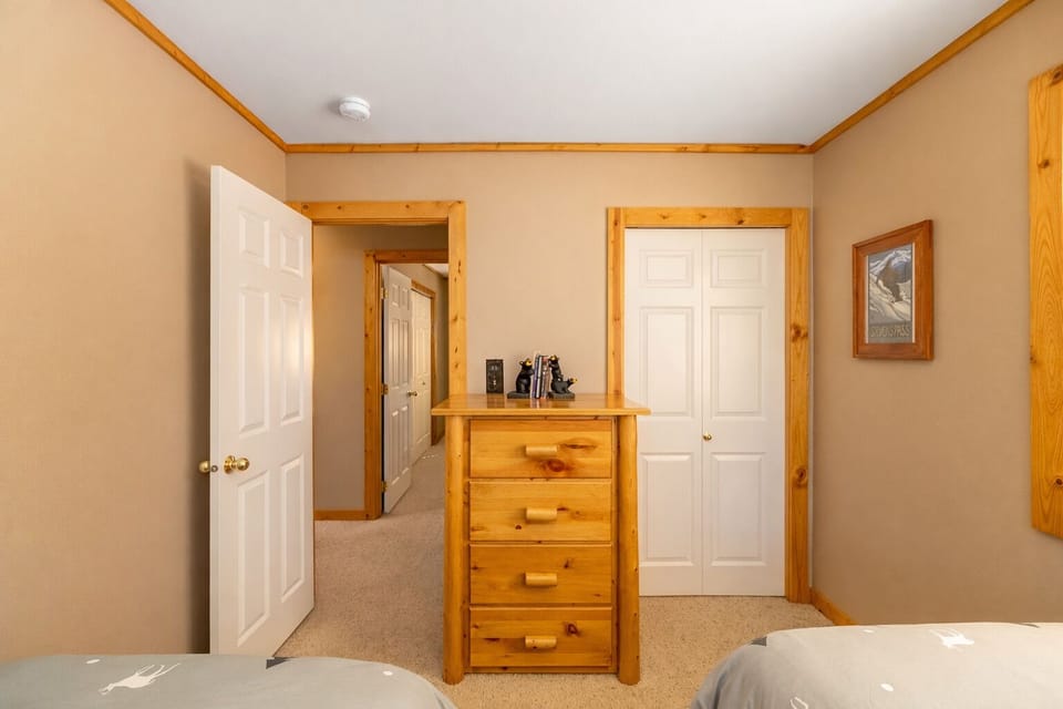 Comfortable bedroom with warm wood furnishings, soft linens, and plenty of storage for your stay.