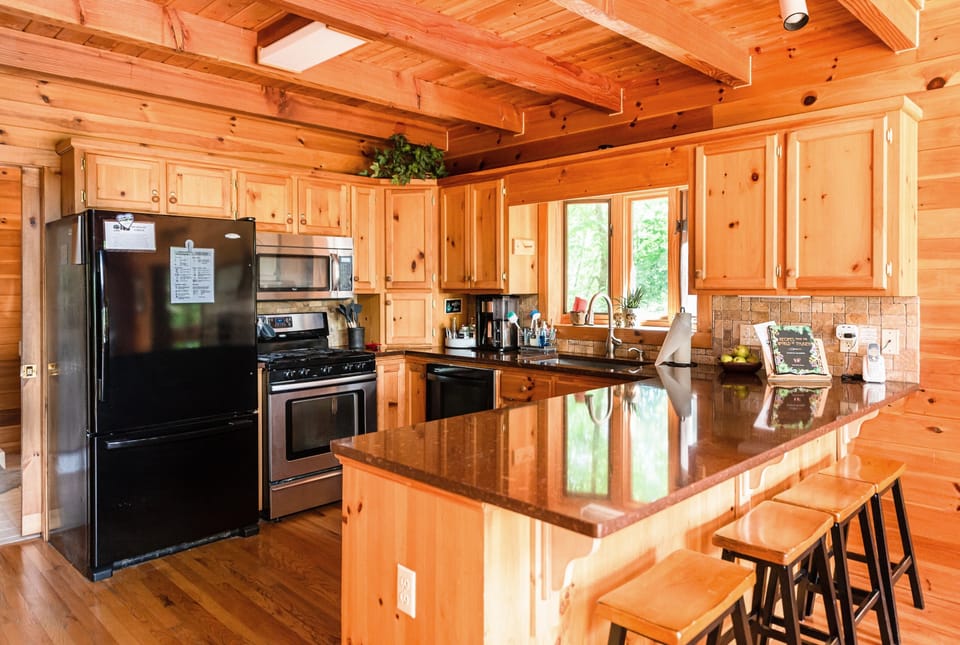 Well-equipped kitchen with cookware, a complete set of dishware, glassware, silverware, and basic pantry items