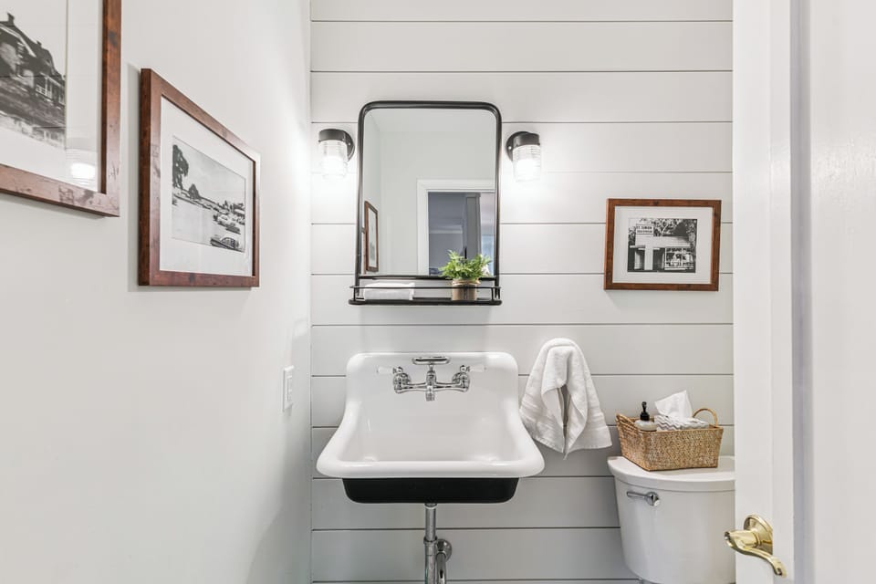 Freshen up in this charming farmhouse powder room with vintage sink and warm touches.