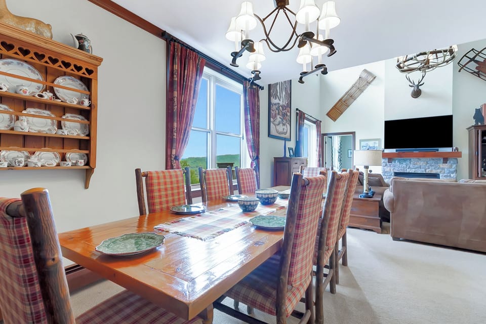 - Rustic dining area with handcrafted wood table and bright windows   - Scenic forest views add to the authentic mountain atmosphere   - Perfect for cozy dinners and après-ski gatherings at Stratton
