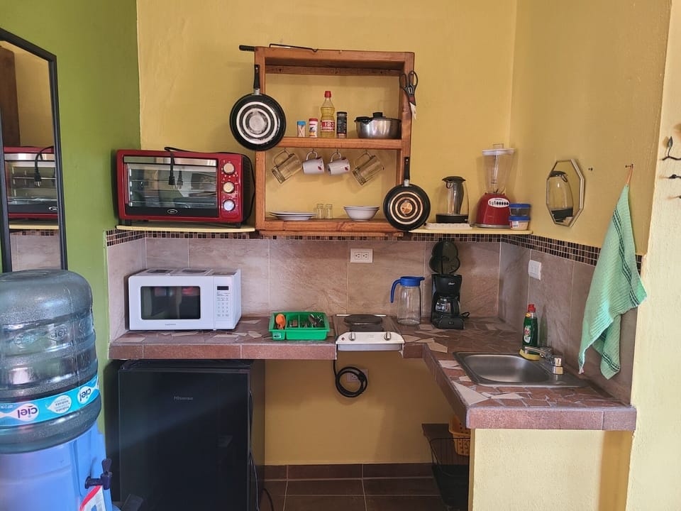 Full kitchen, sink, small fridge/freezer, stove tops, oven, microwave, pots pans