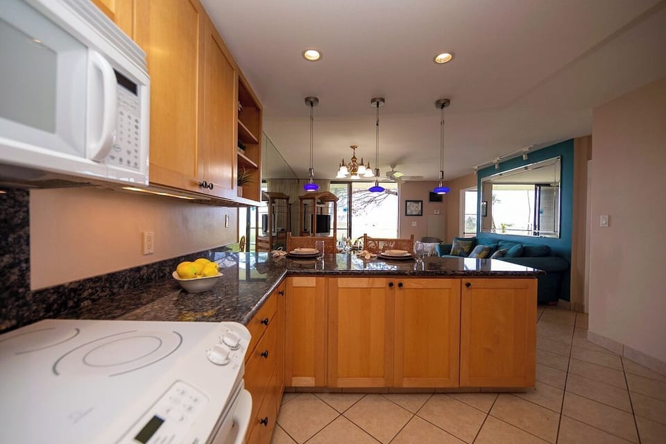 Fully equipped kitchen with ample cabinets and open sightlines to living area.