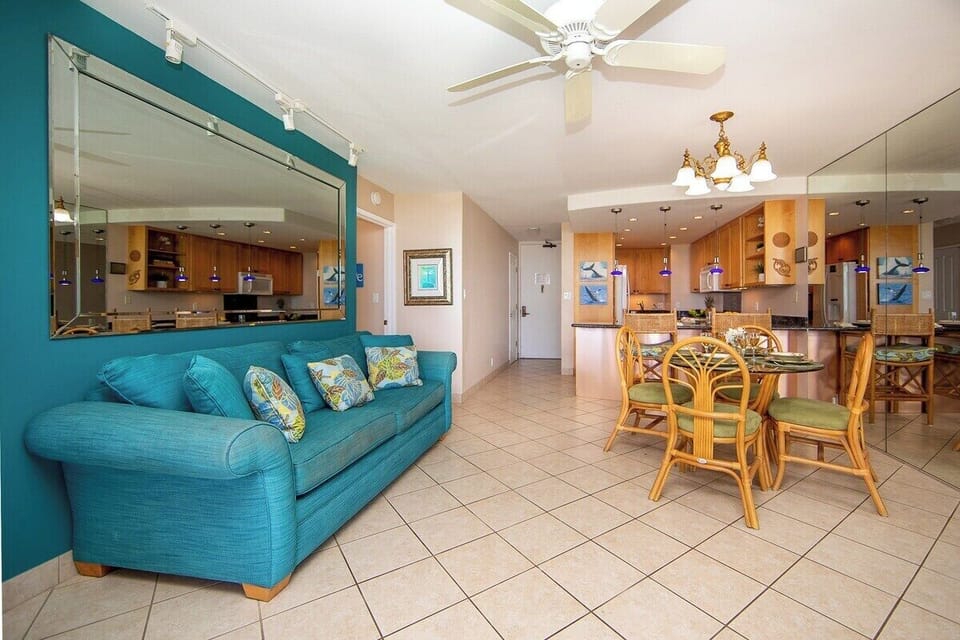 Bright open living area with sleeper sofa, dining space, and full kitchen.