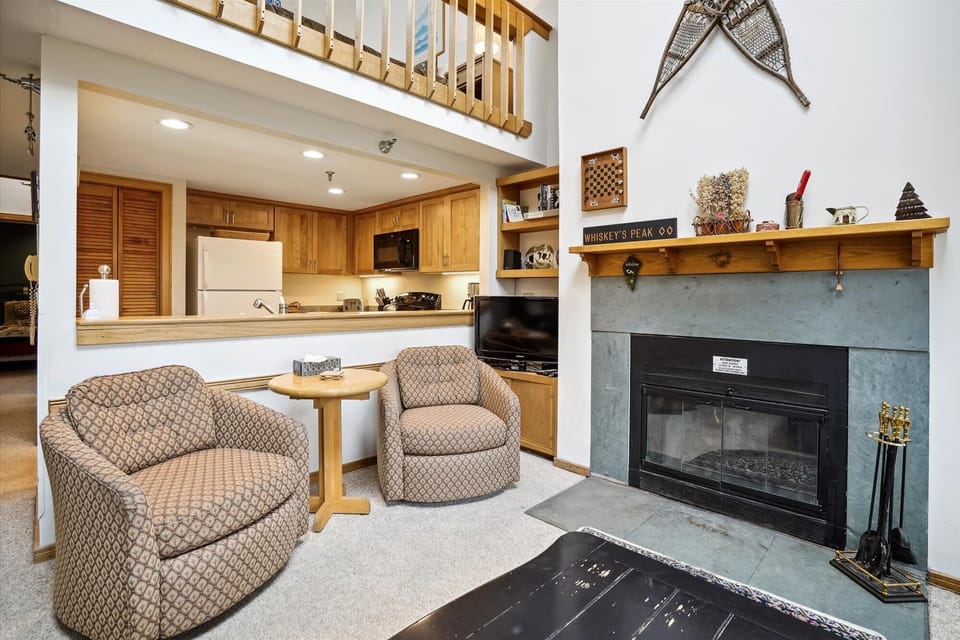 Comfortable seating area with fireplace and easy access to the kitchen, perfect for relaxing after a day on the mountain.