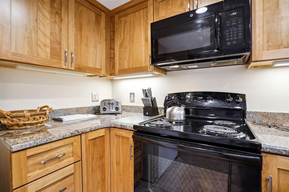 Modern kitchen space featuring ample counter space, electric range, microwave, and convenient prep areas