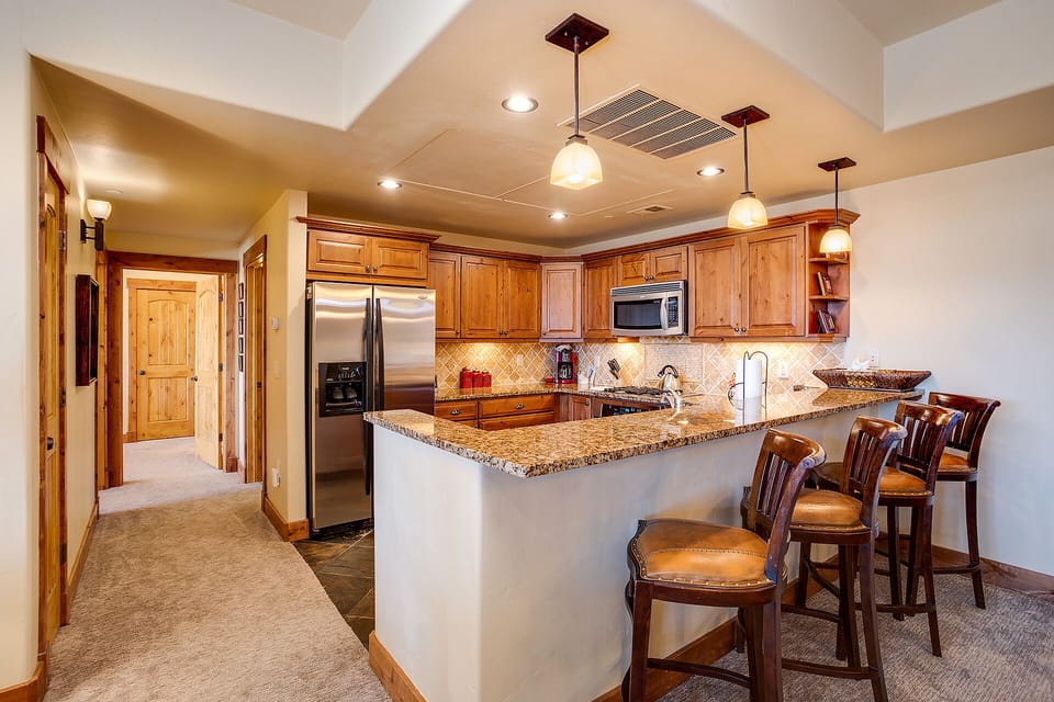 Your gourmet kitchen features granite counters, stainless appliances, and a breakfast bar where you can savor morning coffee together.