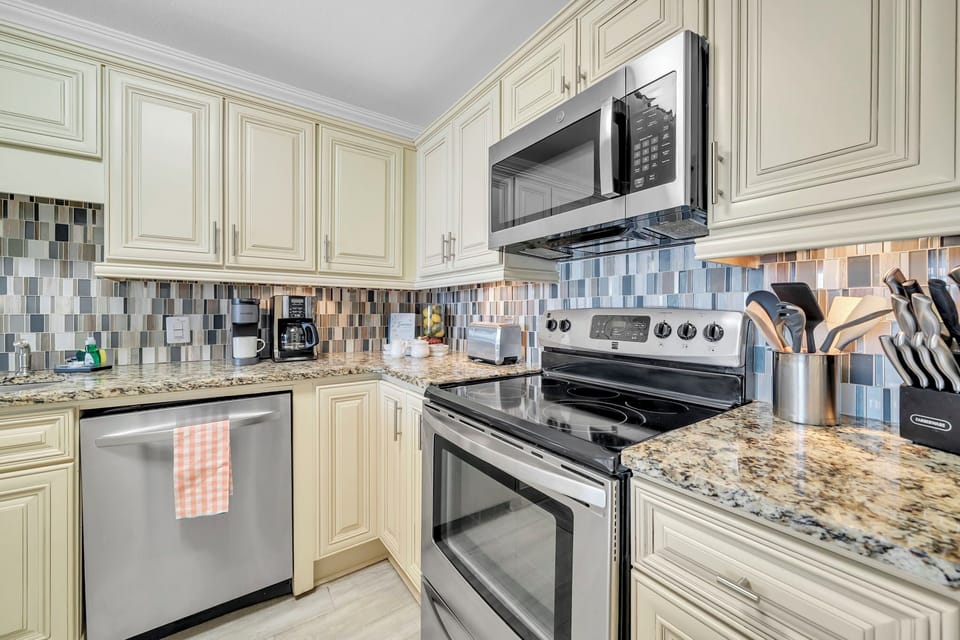 Your fully equipped kitchen invites culinary adventures with generous counterspace and a charming mosaic backsplash lighting up your cooking zone.