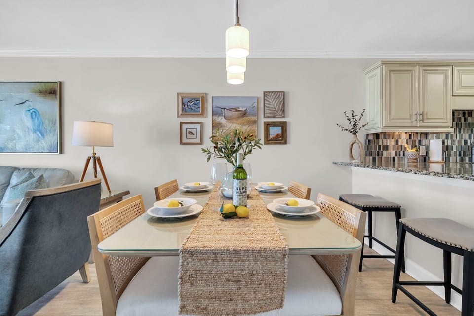 Gather around this elegant dining space where elegant art and warm lighting create the perfect setting for sharing meals.