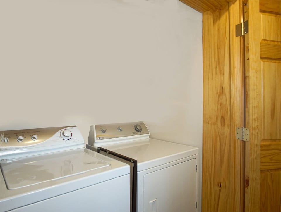 The washer and dryer are located in a small closet in the hallway.