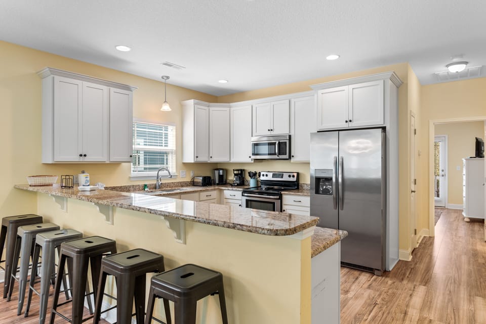 Cook memorable meals in this spacious kitchen featuring granite countertops, stainless steel appliances, and a breakfast bar perfect for morning coffee.