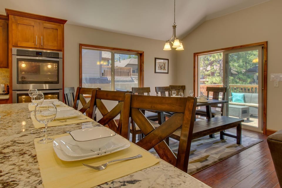 - Kitchen island with granite countertop  
- Dining chairs and table set for meals  
- Sliding doors open to outdoor deck