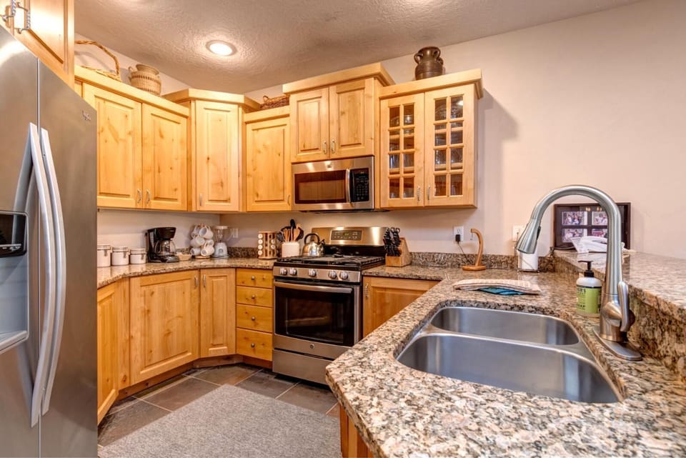Your fully equipped kitchen features granite counters, appliances, and bar seating for easy snacks or casual meals.