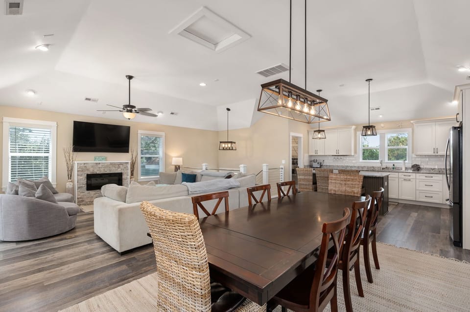 Dining table with a chic lamp, adjoining the living room with a smart TV.