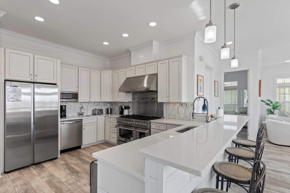 Modern kitchen w/ stainless appliances, island seating, and ample prep space.