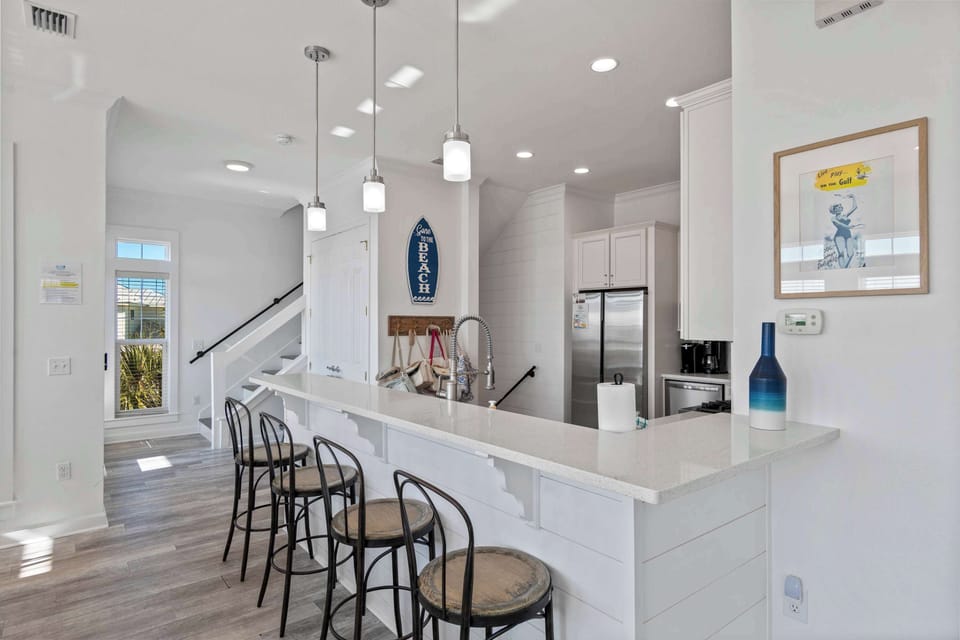 Open kitchen bar w/ stools, pendant lighting, and a clean modern look.