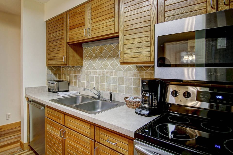 Modern kitchen with stainless steel appliances and wood cabinetry.
