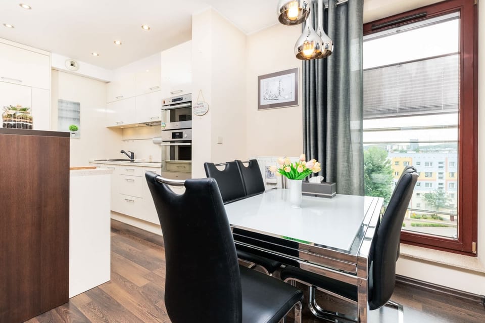 Dining area by the window with a modern table and a view of the surroundings.
