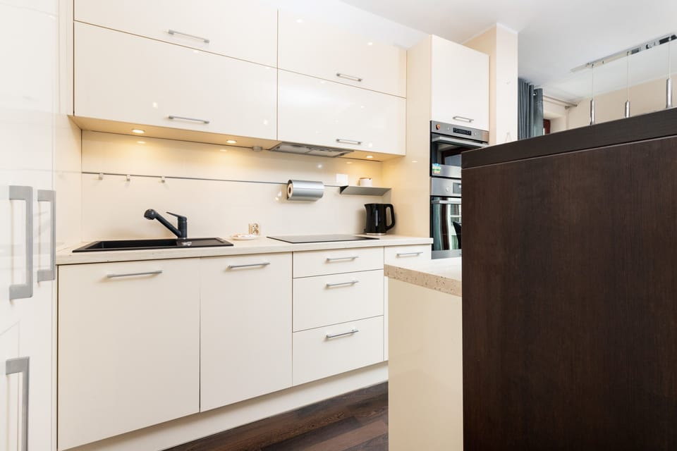 Elegant white kitchen cabinetry with LED lighting.

